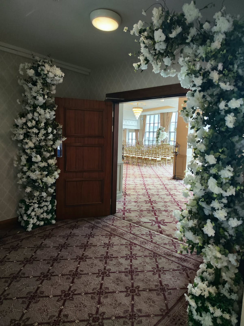White Meadow floral arch at a hotel ceremony entrance