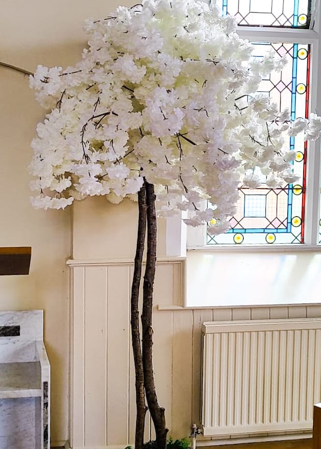 Meadow ceremony decor with floral arch, pew flowers and lanterns