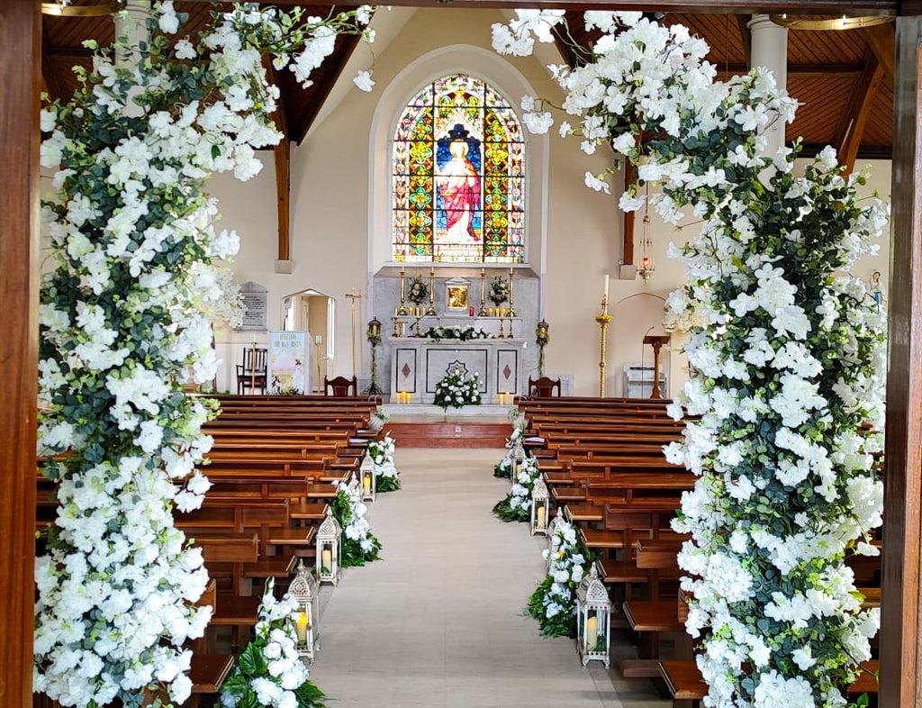 Meadow wedding church decor with blossom trees and rustic lanterns