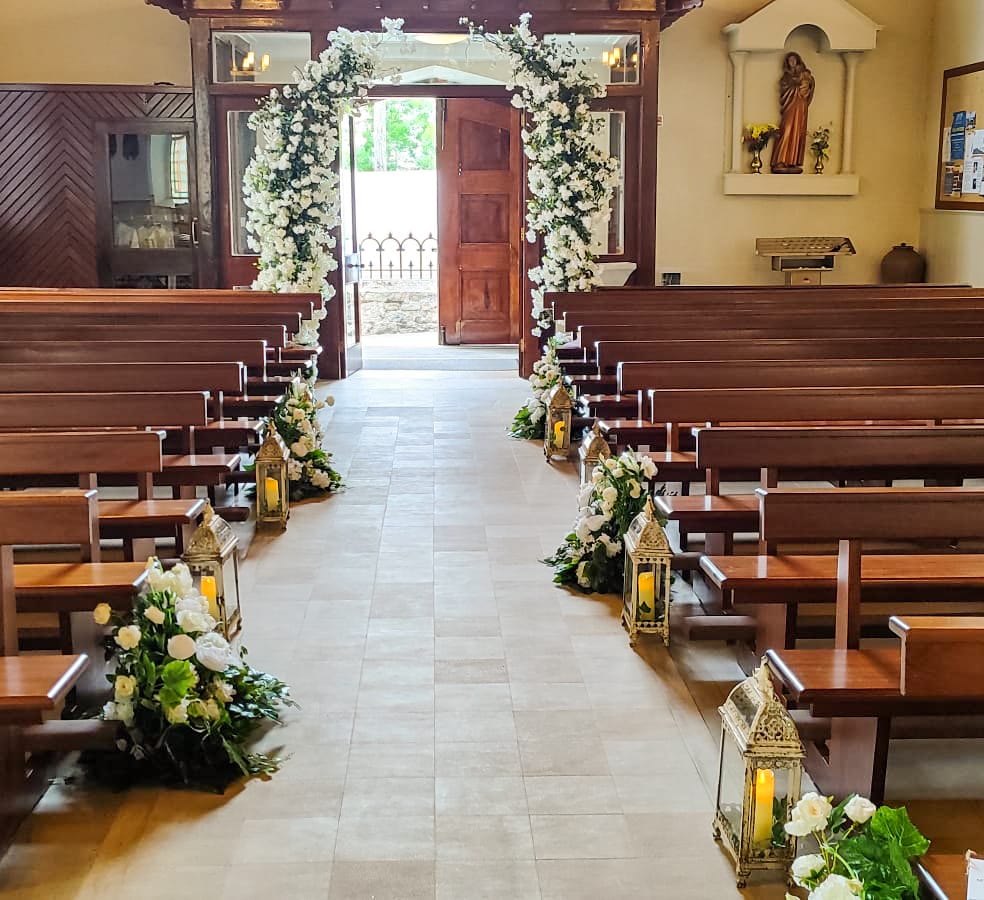 Meadow civil ceremony decor with white floral arch and aisle styling