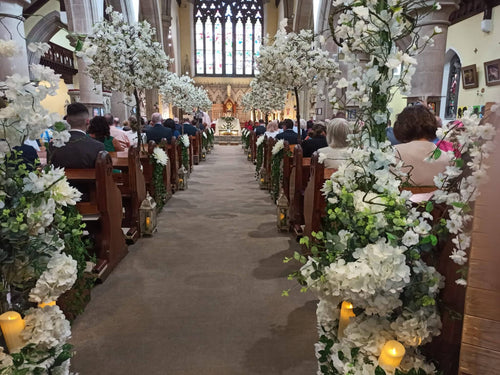 Cherry blossom church ceremony aisle with artificial blossom trees and floral pew ends