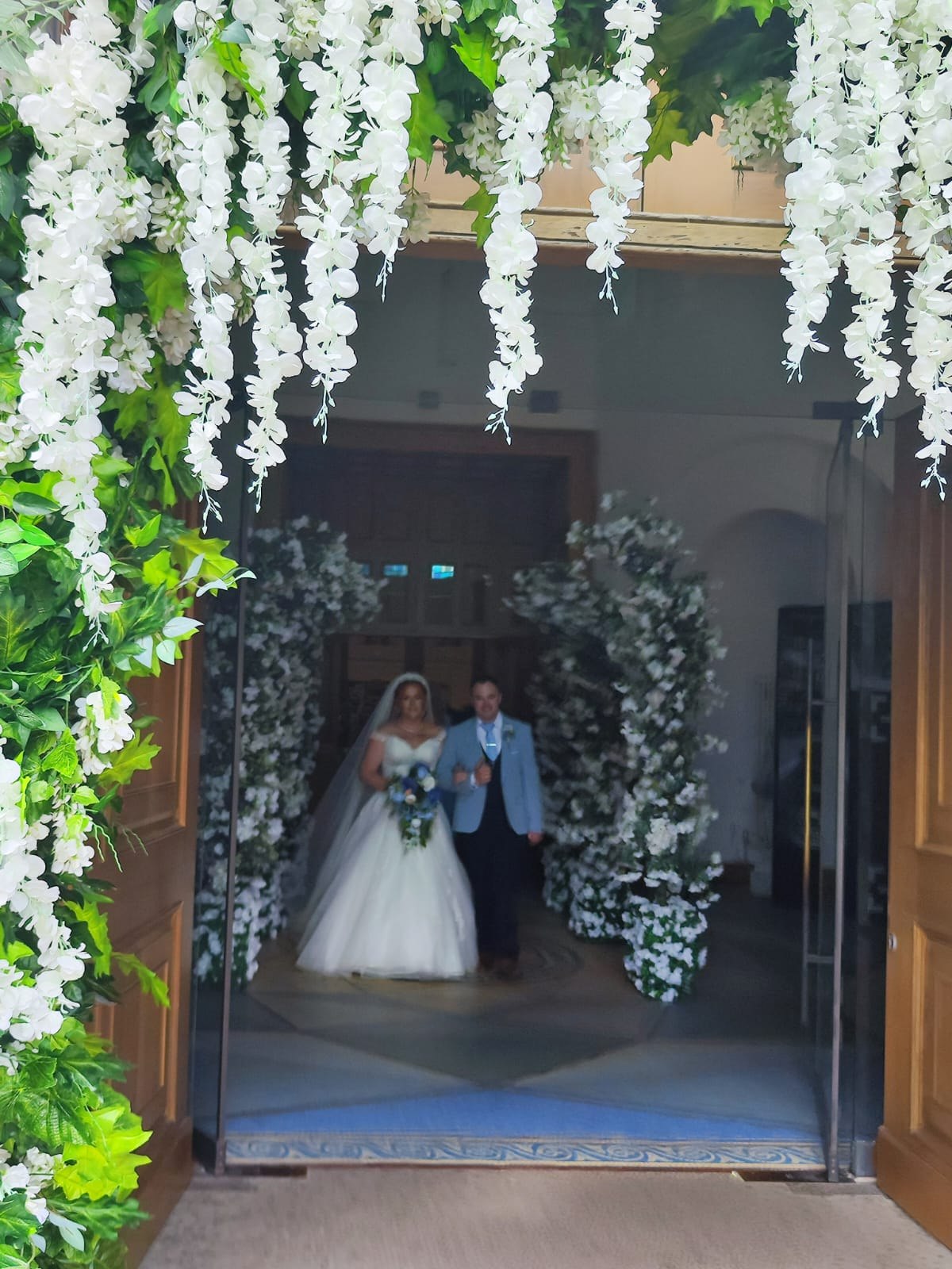 Bride and groom framed inside an Enchanted blossom doorway arch