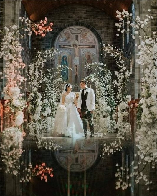 Bride and groom portrait reflected in ornate blossom ceremony styling